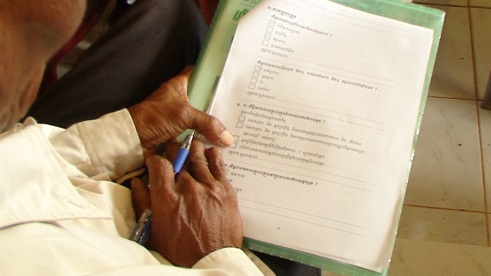 Survivors at the public forum in Kep filling out forms detailing their experiences.